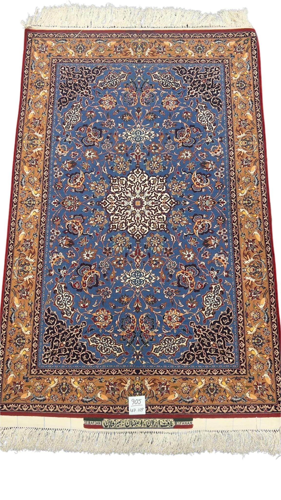 Hand-knotted Seirafian rug in blue and gold with intricate floral patterns.